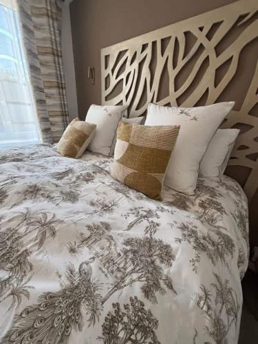 a large bed with a black and white blanket and pillows at Le Domaine de Darvoy in Darvoy