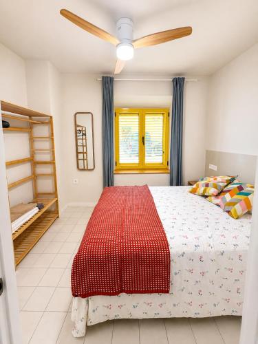 a bedroom with a bed and a ceiling fan at Casa Soleá- a dos min de la playa in Castell de Ferro