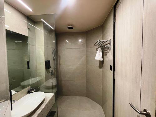 a bathroom with a glass shower and a sink at Hotel Cloud by ARIENA in Phundardih