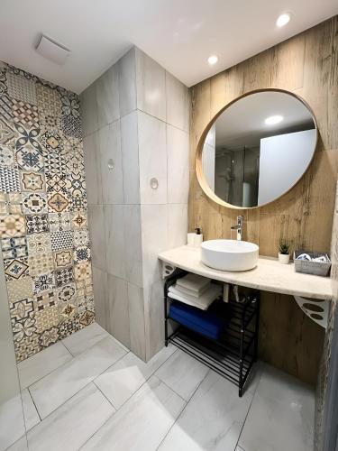 a bathroom with a sink and a mirror at Traumhaftes Studio mit Meerblick & Pool in Khlorakas