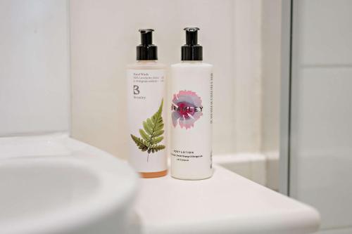 two bottles ofodorizers are sitting on a bathroom counter at Tiger Inn - Grace in Eastbourne