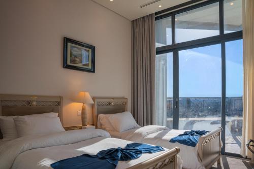 a hotel room with two beds and a large window at Armada Avenue Hotel Amman in Amman