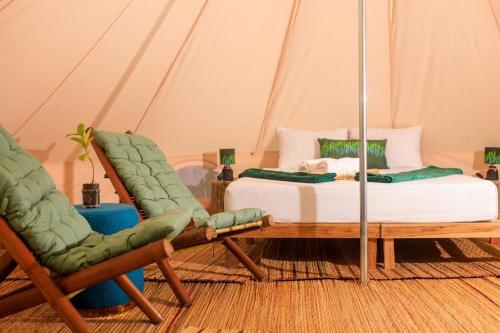 a room with two beds and two chairs in a tent at Barreo Nova Eco Resort in Abrafo