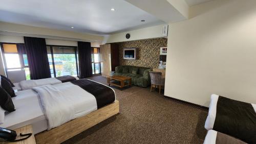 a hotel room with two beds and a living room at Sky Airport Hotel - فندق سما المطار in Al Mawşil
