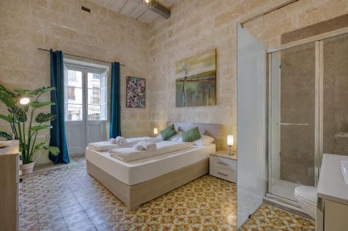 ein Schlafzimmer mit einem großen Bett und einer Dusche in der Unterkunft Heart of Gozo - Modern Rooms in shared Apartment - Victoria D-Central opposite Duke Shopping Center in Victoria