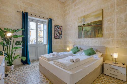 ein Schlafzimmer mit einem großen Bett, auf dem Handtücher liegen in der Unterkunft Heart of Gozo - Modern Rooms in shared Apartment - Victoria D-Central opposite Duke Shopping Center in Victoria
