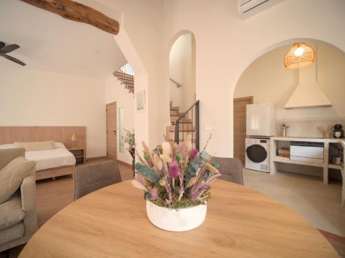 a living room with a table with a vase of flowers at El Passeig Rural in Castalla