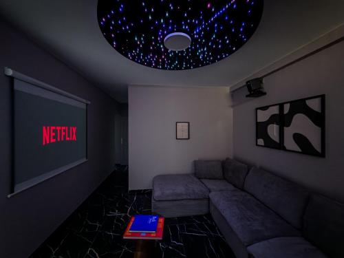 a living room with a couch and a tv at Galaxy Mood - 10 min Disney in Couilly-Pont-aux-Dames