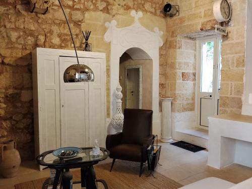 a living room with a chair and a table at B&B "Pulia Dimore Salentine" in Alessano