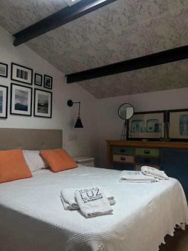 a bedroom with a bed with towels on it at HOTEL LUZ ALMONASTER in Almonaster la Real