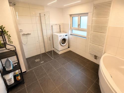 a bathroom with a washing machine and a washer at Apartment 98 - 2 Schlafzimmer, Balkon & Vogelsbergblick in Hungen