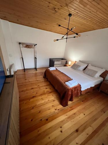 a bedroom with a large bed and a wooden ceiling at Domacinstvo Paprica Tjentiste in Foča