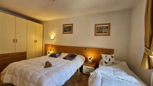 a bedroom with two beds in a room at Baita dei Pini in Campodolcino