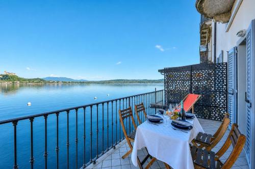 a table on a balcony with a view of the water at Aparthotel Arona in Arona