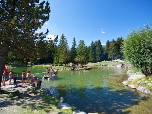 een groep mensen die in het water bij een meer staan bij Schweizerhof Ferienwohnungen Lenzerheide 5 in Lenzerheide