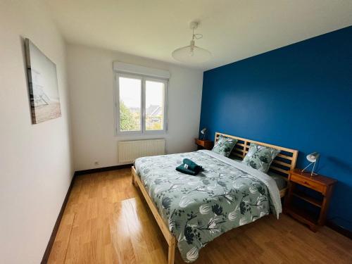 a bedroom with a bed with a blue wall at Gîte la Blanchère in Saint-Herblon