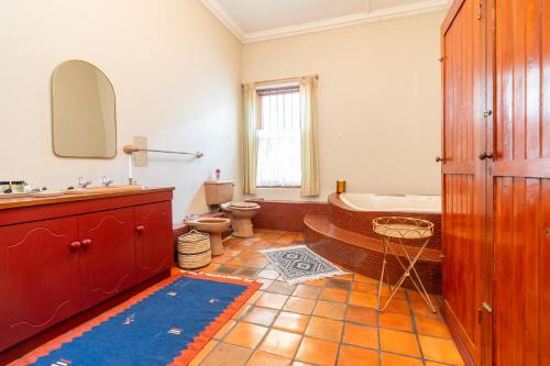 a bathroom with a tub and a toilet and a sink at Elizabeth's Cottage in Montagu