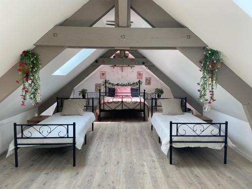a attic bedroom with two beds and a ceiling at Lys in Gury