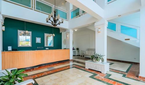 eine leere Lobby mit einer grünen Wand in der Unterkunft Hotel Checkin El Cortecito in Punta Cana