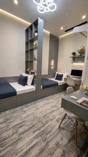 a living room with two beds and a desk at NestOne Apartment 39th floor in Tashkent