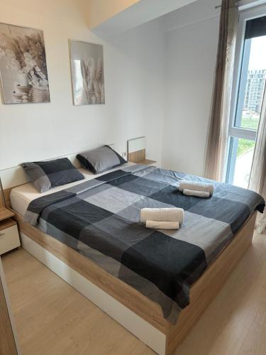 a large bed in a bedroom with two towels on it at Suba's Apartment Free Parking Self Check-in in Timişoara