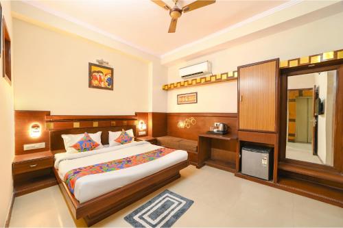 a bedroom with a large bed and a mirror at FabHotel Aayansh in Jaipur
