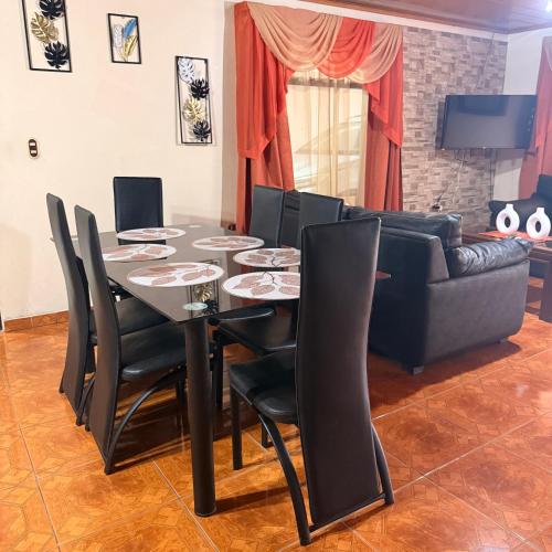 a dining room with a table and a couch at Villa Gonz in Río Cuarto