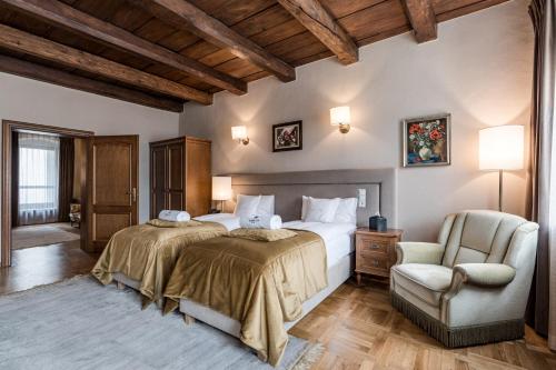 a bedroom with a bed and a chair at Hotel Rubinstein in Krakow