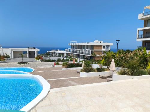 a view of a swimming pool and some buildings at Luxury Sea & Pool View Apt at Caesar Cliff Esentepe in Perivolia tou Trikomou