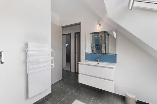 a white bathroom with a sink and a mirror at Maison La Plouhinecoise in Plouhinec