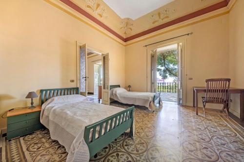 a bedroom with two beds and a balcony at Villa Charme Lipari in Lipari