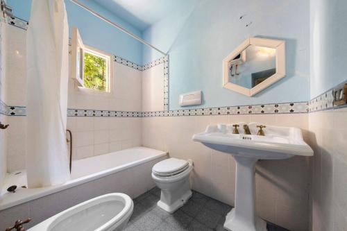 a white bathroom with a sink and a toilet at Villa Charme Lipari in Lipari