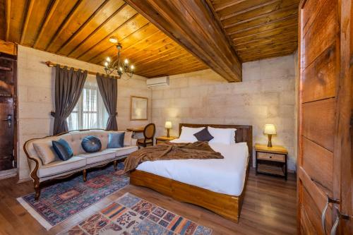 a bedroom with a bed and a couch in a room at Duven Hotel Cappadocia in Uçhisar