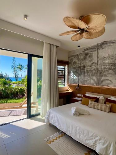 a bedroom with a bed and a ceiling fan at Exclusive beachfront apartment in Belle Mare