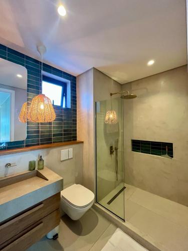a bathroom with a toilet and a glass shower at Exclusive beachfront apartment in Belle Mare