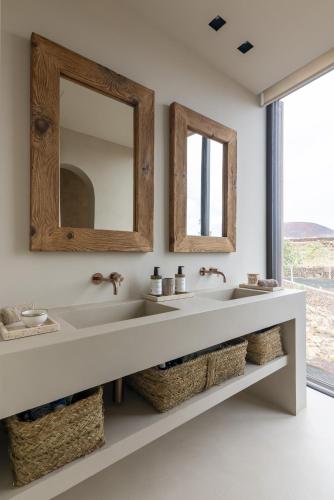 a bathroom with two sinks and a mirror at Villa Gara exclusive luxury villa with heated pool in Lajares