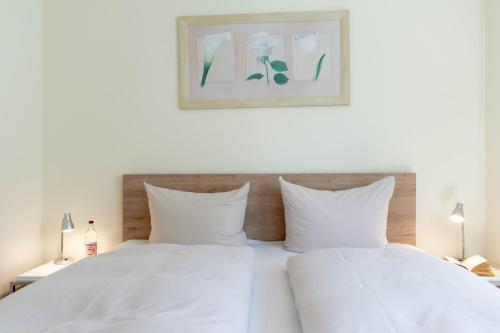 a bedroom with a white bed with two white pillows at Ferienwohnung Seestern in Timmendorfer Strand