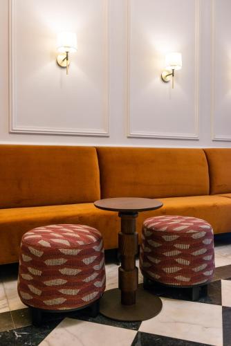 a couch with a table and two stools at Hotel Vasanta in Barcelona