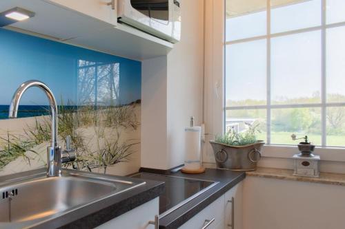 a kitchen with a sink and a large window at Ferienwohnung Ankommen in Timmendorfer Strand
