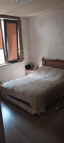 a bedroom with a large bed with a window at Dvalebi's Marani in Gori