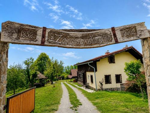 a sign for a farm in front of a house at Home in Heaven I Historical Log House in Šentrupert