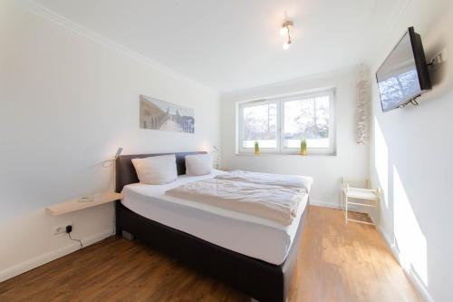 a small bedroom with a bed and a window at Ferienwohnung Dünenhäuser App. A2 in Scharbeutz