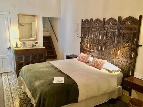 a bedroom with a large bed with a wooden headboard at Número 9 in Medina Sidonia