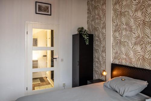 a bedroom with a bed and a mirror at Appartement B&B In de Gulde Steur in Deventer