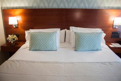 Una cama o camas en una habitación de Hotel Carlos I Silgar