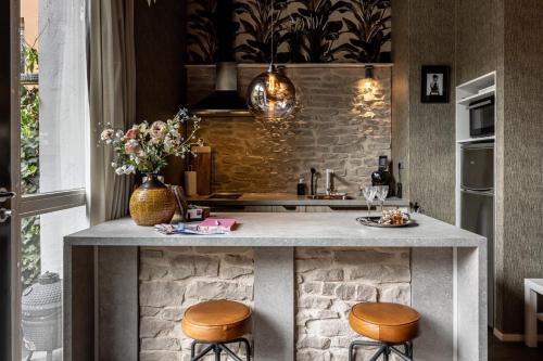 a kitchen with a counter with two stools at Appartement B&B In de Gulde Steur in Deventer
