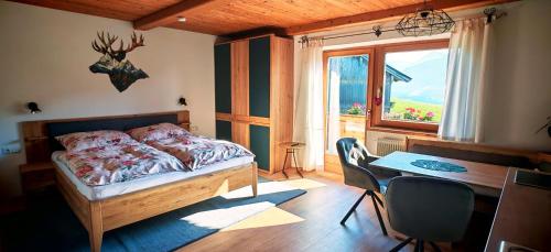 a bedroom with a bed and a table and a window at Obernberg in Aurach bei Kitzbuhel