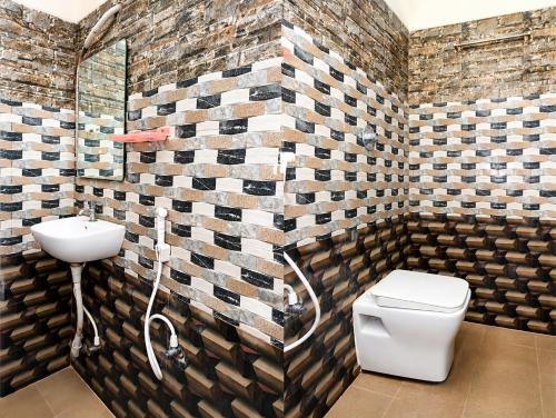 a bathroom with a toilet and a sink at Hotel Amaravathi Grand in Vijayawāda