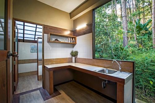 une salle de bain avec un lavabo et une fenêtre dans l'établissement Khaokhoherbary OrganicFarm&Resort, à Khao Kho