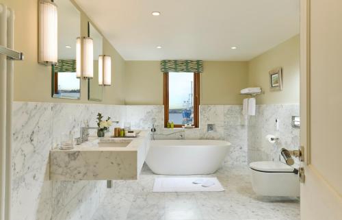 a bathroom with a tub and a sink and a toilet at Trident Hotel Kinsale in Kinsale